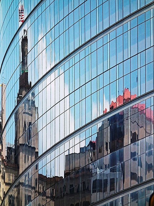 Old Presbyterian Hospital reflected in curved surface of new