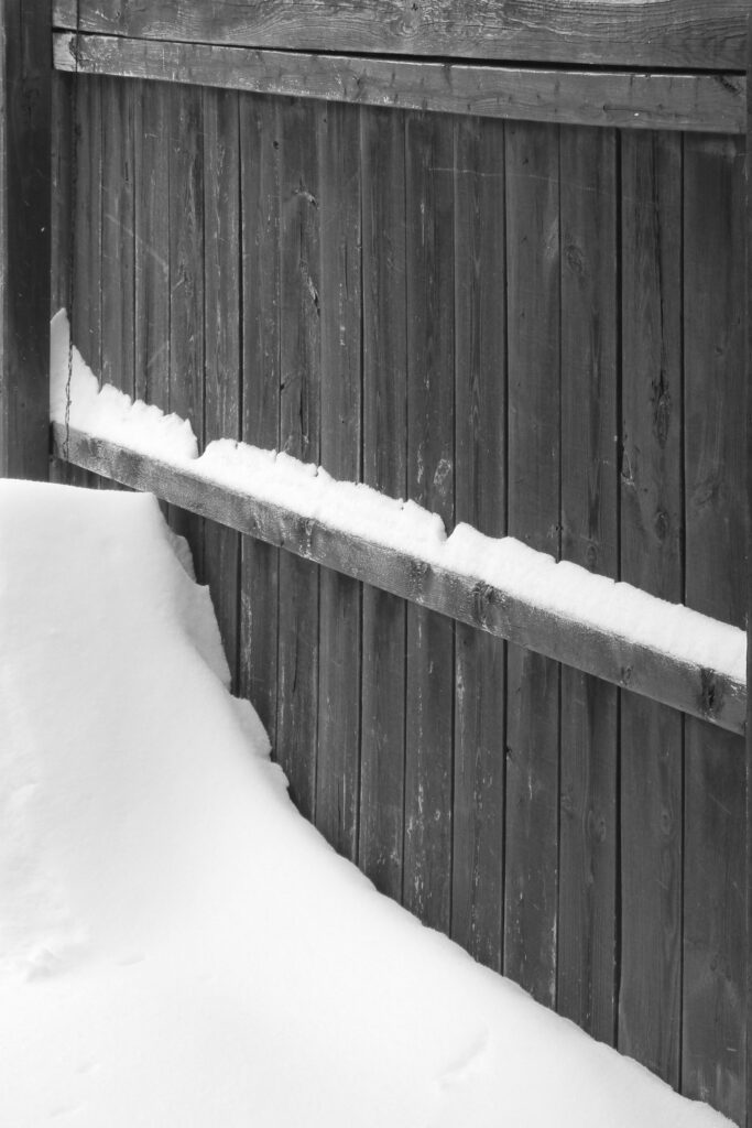 Fence with mound of drifted snow.