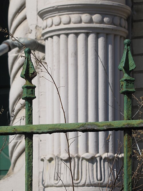 Wrought-iron fence with pilaster in background